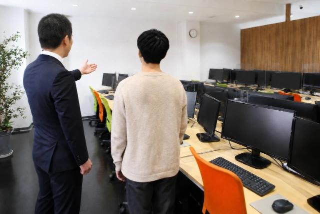 スタッフの案内で事業所内を見学する様子