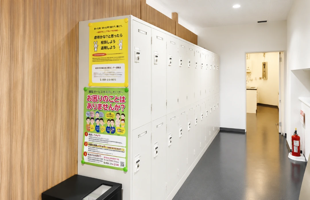 利用者用ロッカーが並ぶ事業所内の通路