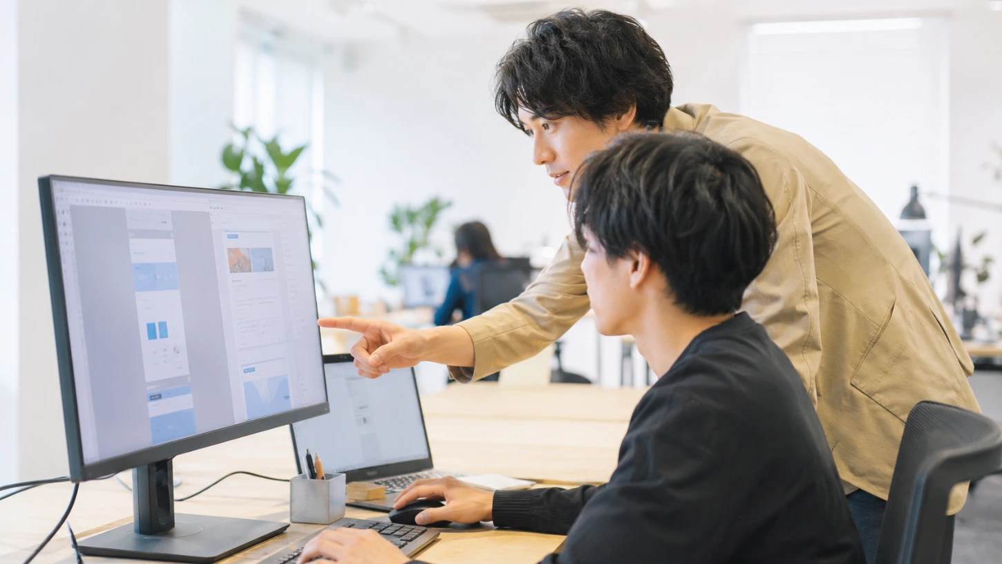 Webディレクターが利用者の画面を確認しながら指導している仕事風景